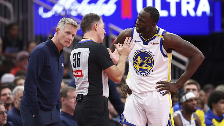 Dec 11, 2024; Houston, Texas, USA; Golden State Warriors head coach Steve Kerr looks on as forward Draymond Green (23) talks with an official during the first half against the Houston Rockets at Toyota Center. Mandatory Credit: Troy Taormina-Imagn Images