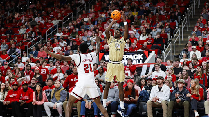 Jan 17, 2026; Raleigh, North Carolina, USA; Georgia Tech Yellow Jackets forward Kowacie Reeves Jr. (14) shoots a three pointers past NC State Wolfpack guard Terrance Arceneaux (21) during the second half of the gameat Lenovo Center. Mandatory Credit: Jaylynn Nash-Imagn Images