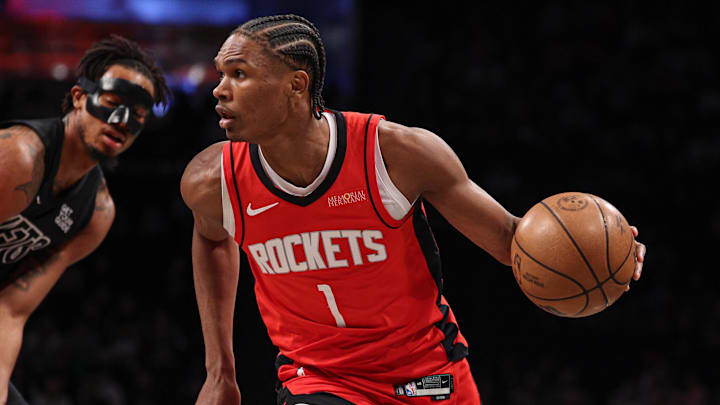 Feb 4, 2025; Brooklyn, New York, USA; Houston Rockets forward Amen Thompson (1) dribbles in front of Brooklyn Nets center Nic Claxton (33) during the first quarter at Barclays Center. Mandatory Credit: Vincent Carchietta-Imagn Images