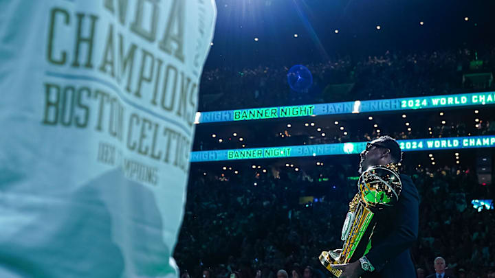 Oct 22, 2024; Boston, Massachusetts, USA; Former NBA Champion and Boston Celtics player Paul Pierce carries out the championship trophy onto the court during the opening night banner raising ceremony before the start of the game against the New York Knicks at TD Garden. Mandatory Credit: David Butler II-Imagn Images