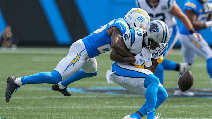 Sep 15, 2024; Charlotte, North Carolina, USA; Los Angeles Chargers cornerback Asante Samuel Jr. (26) tackles Carolina Panthers defensive end LaBryan Ray (93) during the second half at Bank of America Stadium. 