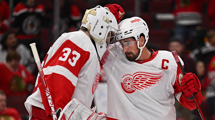 Oct 1, 2022; Chicago, Illinois, USA; Detroit Red Wings goaltender Sebastian Cossa (33) and forward Dylan Larkin (71) celebrate their 3-0 win over the Chicago Blackhawks at the United Center. Mandatory Credit: Jamie Sabau-Imagn Images
