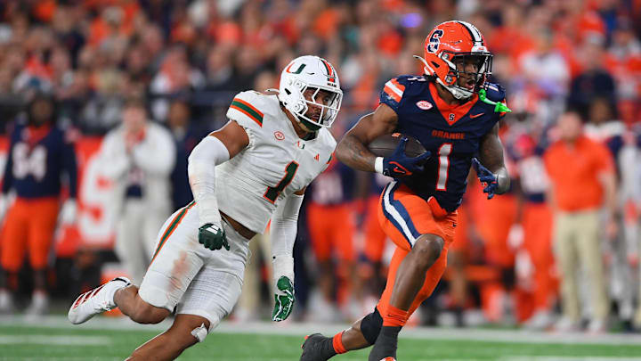 Nov 30, 2024; Syracuse, New York, USA; Syracuse Orange running back LeQuint Allen (1) runs with the ball against Miami Hurricanes linebacker Francisco Mauigoa (1) during the second half at the JMA Wireless Dome