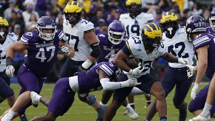 Nov 15, 2025; Chicago, Illinois, USA; Northwestern Wildcats defensive back Braden Turner (9) tackles Michigan Wolverines running back Jordan Marshall (23) during the first half at Wrigley Field. Mandatory Credit: David Banks-Imagn Images