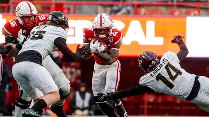 Oct 28, 2023; Lincoln, Nebraska, USA; Nebraska Cornhuskers running back Emmett Johnson (21) runs against Purdue Boilermakers linebacker Yanni Karlaftis (14) during the fourth quarter at Memorial Stadium. Oct 28, 2023; Lincoln, Nebraska, USA; Nebraska Cornhuskers running back Emmett Johnson (21) runs against Purdue Boilermakers linebacker Yanni Karlaftis (14) during the fourth quarter at Memorial Stadium.
