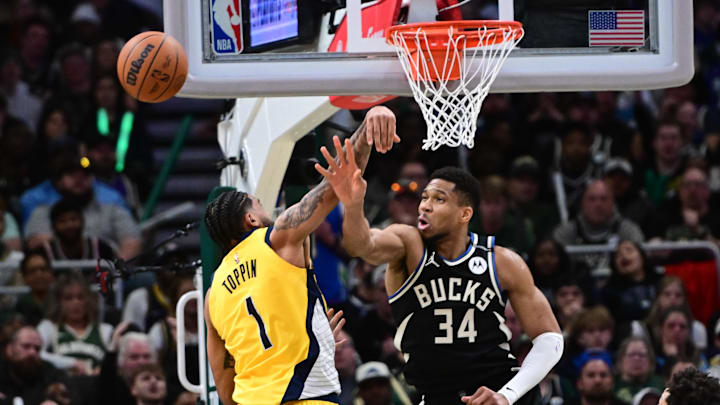 Apr 27, 2025; Milwaukee, Wisconsin, USA; Milwaukee Bucks forward Giannis Antetokounmpo (34) and Indiana Pacers forward Obi Toppin (1) reach for the ball in the third quarter during game four of first round for the 2024 NBA Playoffs at Fiserv Forum. Mandatory Credit: Benny Sieu-Imagn Images