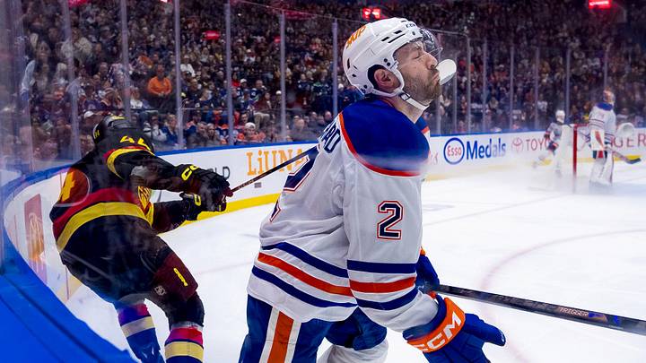 Jan 18, 2025; Vancouver, British Columbia, CAN; Vancouver Canucks forward Kiefer Sherwood (44) high sticks Edmonton Oilers defenseman Evan Bouchard (2) in the second period at Rogers Arena. Mandatory Credit: Bob Frid-Imagn Images