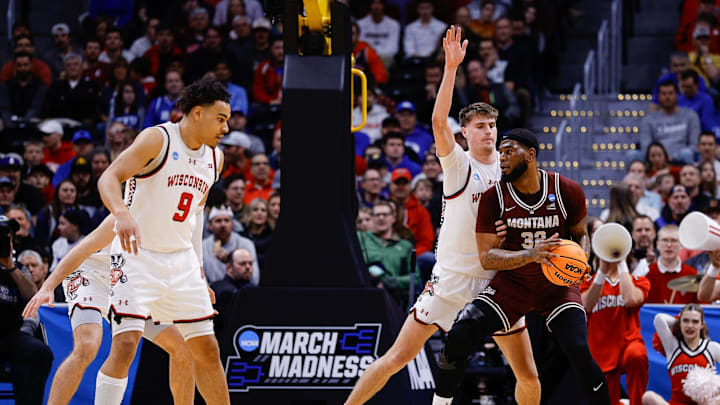 Mar 20, 2025; Denver, CO, USA; Wisconsin Badgers forward Nolan Winter (31) defends against Montana Grizzlies forward Te'Jon Sawyer (32) during the first half in the first round of the NCAA Tournament at Ball Arena. Mandatory Credit: Isaiah J. Downing-Imagn Images