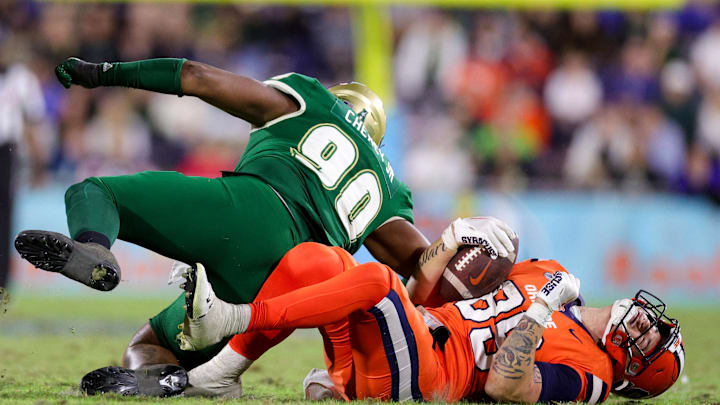 Dec 21, 2023; Boca Raton, FL, USA;  South Florida Bulls defensive lineman Rashad Cheney (90) tackles Syracuse Orange tight end Dan Villari (89) in the third quarter during the RoofClaim.com Boca Raton Bowl at FAU Stadium. Mandatory Credit: Nathan Ray Seebeck-Imagn Images