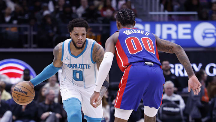 Jan 3, 2025; Detroit, Michigan, USA;  Charlotte Hornets forward Miles Bridges (0) dribbles against Detroit Pistons forward Ronald Holland II (00) in the first half at Little Caesars Arena. Mandatory Credit: Rick Osentoski-Imagn Images