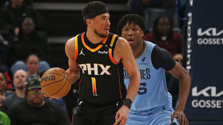 Phoenix Suns guard Devin Booker handles the ball a Memphis Grizzlies forward GG Jackson II defends.