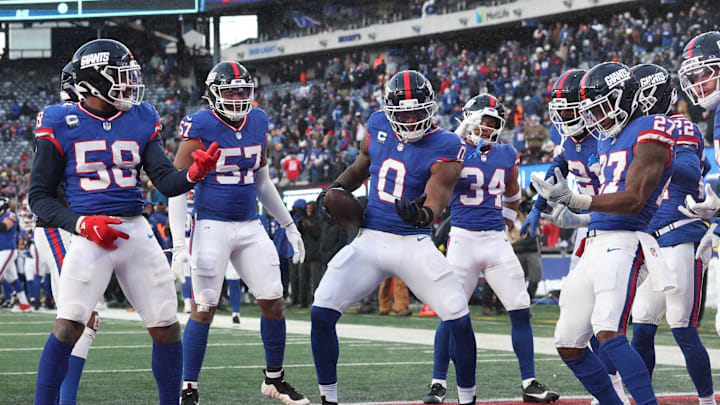 Dec 14, 2025; East Rutherford, New Jersey, USA;  New York Giants linebacker Brian Burns (0) celebrates a fumble recovery with teammates during the fourth quarter against the Washington Commanders at MetLife Stadium.  