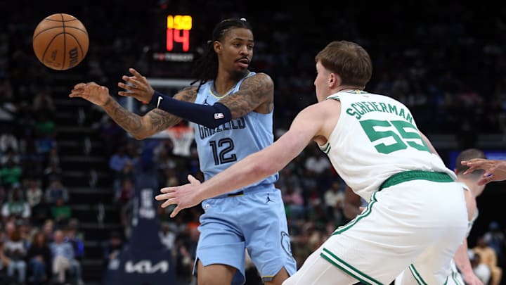 Mar 31, 2025; Memphis, Tennessee, USA; Memphis Grizzlies guard Ja Morant (12) passes the ball as Boston Celtics forward Baylor Scheierman (55) defends during the third quarter at FedExForum. Mandatory Credit: Petre Thomas-Imagn Images