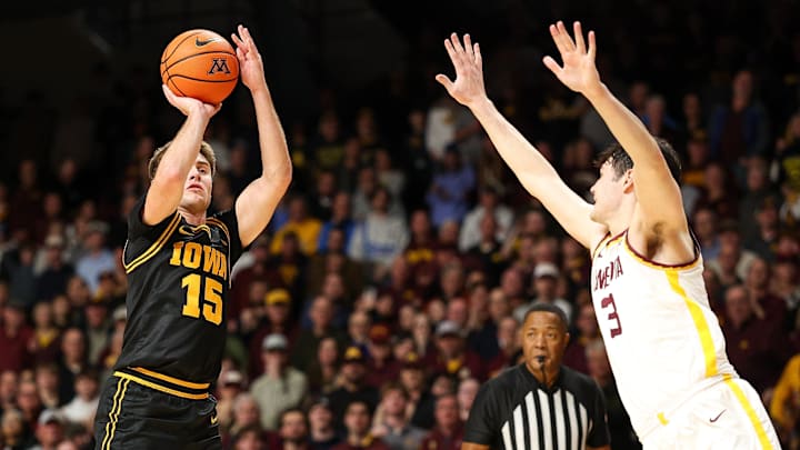 Jan 6, 2026; Minneapolis, Minnesota, USA; Iowa Hawkeyes guard Brendan Hausen (15) shoots as Minnesota Golden Gophers forward Bobby Durkin (3) defends during the second half at Williams Arena. Mandatory Credit: Matt Krohn-Imagn Images