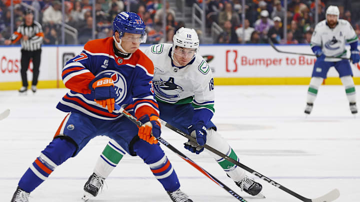 Sep 28, 2025; Edmonton, Alberta, CAN; Edmonton Oilers defensemen Atro Leppanen (37) moves the puck in front of Vancouver Canucks forward Drew O'Connor (18) during the second period at Rogers Place. Mandatory Credit: Perry Nelson-Imagn Images Sep 28, 2025; Edmonton, Alberta, CAN; Edmonton Oilers defensemen Atro Leppanen (37) moves the puck in front of Vancouver Canucks forward Drew O'Connor (18) during the second period at Rogers Place. Mandatory Credit: Perry Nelson-Imagn Images