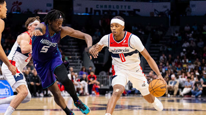 Mar 1, 2025; Charlotte, North Carolina, USA; Washington Wizards guard Bilal Coulibaly (0) drives past Charlotte Hornets center Mark Williams (5) during the fourth quarter at Spectrum Center. Mandatory Credit: Scott Kinser-Imagn Images
