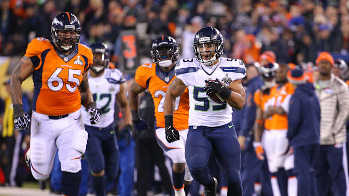 Feb 2, 2014; East Rutherford, NJ, USA; Seattle Seahawks outside linebacker Malcolm Smith (53) runs for a touchdown after an interception against Denver Broncos guard Louis Vasquez (65) during the first half in Super Bowl XLVIII at MetLife Stadium. Mandatory Credit: Brad Penner-Imagn Images Feb 2, 2014; East Rutherford, NJ, USA; Seattle Seahawks outside linebacker Malcolm Smith (53) runs for a touchdown after an interception against Denver Broncos guard Louis Vasquez (65) during the first half in Super Bowl XLVIII at MetLife Stadium. Mandatory Credit: Brad Penner-Imagn Images