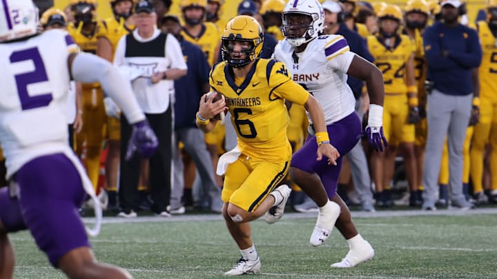 West Virginia University quarterback Garrett Greene scrambles up field against the University at Albany defense. 
