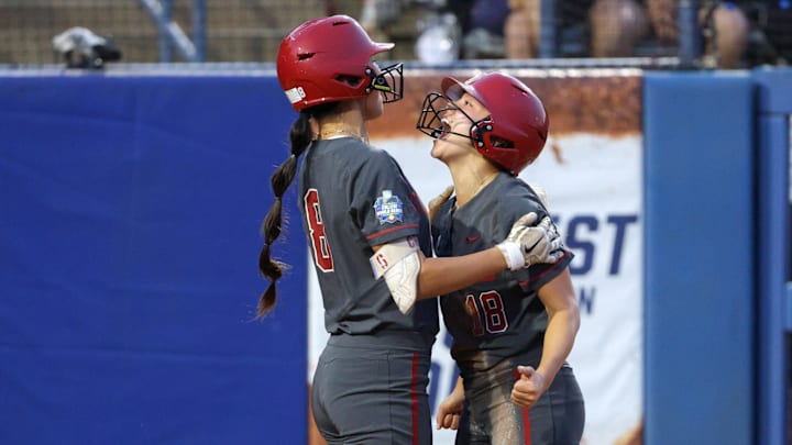 Stanford infielder Emily Jones, right, celebrates with outfielder Kyra Chan after scoring a run in the third inning of a Women's College World Series softball game between the Stanford Cardinal and the UCLA Bruins at Devon Park in Oklahoma City, Sunday, June 2, 2024. Stanford won 3-1.