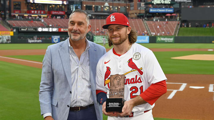 Sep 15, 2025; St. Louis, Missouri, USA; St. Louis Cardinals second baseman Brendan Donovan (21) and President of Baseball Operations John Mozeliak pose for a photo after Donovan is named the St. Louis Cardinals 2025 Roberto Clemente nominee prior to their game against the Cincinnati Reds at Busch Stadium. Mandatory Credit: Joe Puetz-Imagn Images