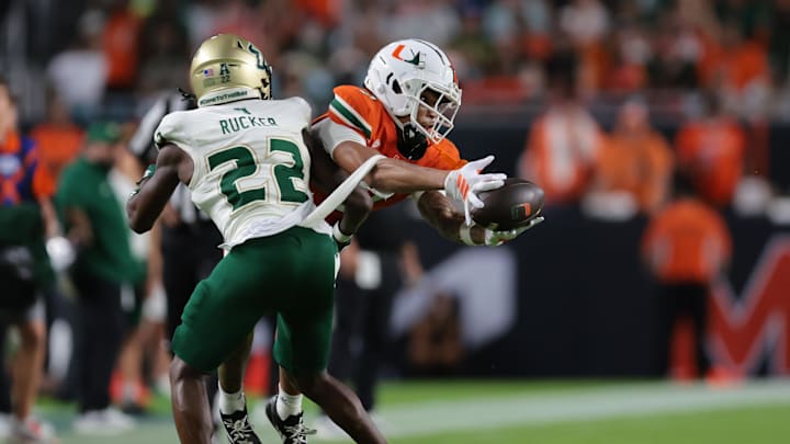 Sep 13, 2025; Miami Gardens, Florida, USA; Miami Hurricanes wide receiver CJ Daniels (7) catches the football against South Florida Bulls cornerback De'Shawn Rucker (22) during the second quarter at Hard Rock Stadium. Mandatory Credit: Sam Navarro-Imagn Images Sep 13, 2025; Miami Gardens, Florida, USA; Miami Hurricanes wide receiver CJ Daniels (7) catches the football against South Florida Bulls cornerback De'Shawn Rucker (22) during the second quarter at Hard Rock Stadium. Mandatory Credit: Sam Navarro-Imagn Images