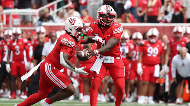Utah Utes quarterback Devon Dampier (4) hands the ball off to Utah Utes running back Wayshawn Parker (1) during the fourth quarter of the game against the Texas Tech Red Raiders at Rice-Eccles Stadium. Utah Utes quarterback Devon Dampier (4) hands the ball off to Utah Utes running back Wayshawn Parker (1) during the fourth quarter of the game against the Texas Tech Red Raiders at Rice-Eccles Stadium.