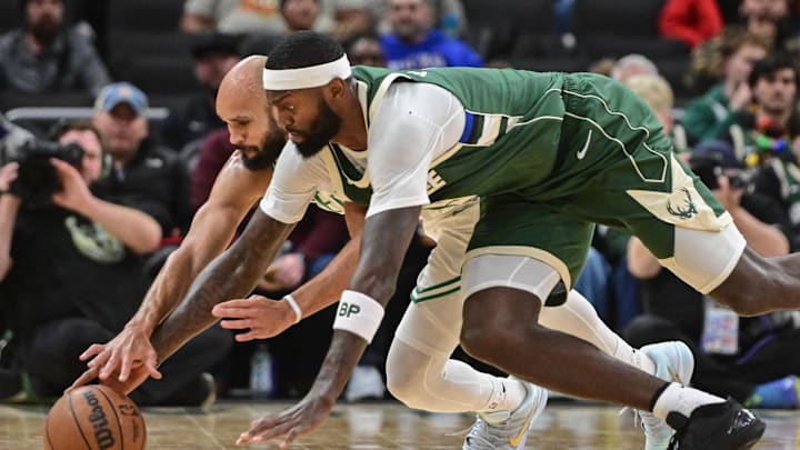 Dec 11, 2025; Milwaukee, Wisconsin, USA;  Milwaukee Bucks forward Bobby Portis (9) and Boston Celtics guard Derrick White (9) reach for a loose ball in the first quarter at Fiserv Forum. Mandatory Credit: Benny Sieu-Imagn Images