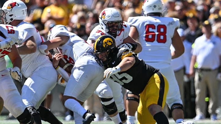 Aug 31, 2024; Iowa City, Iowa, USA; Iowa Hawkeyes defensive lineman Aaron Graves (95) sacks Illinois State Redbirds quarterback Tommy Rittenhouse (16) as offensive lineman Ryan Gudaitis (75) looks on during the second quarter at Kinnick Stadium. Mandatory Credit: Jeffrey Becker-Imagn Images