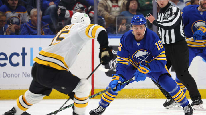 Mar 25, 2026; Buffalo, New York, USA;  Boston Bruins defenseman Jonathan Aspirot (45) makes a pass as Buffalo Sabres center Sam Carrick (10) defends during the second period at KeyBank Center. Mandatory Credit: Timothy T. Ludwig-Imagn Images