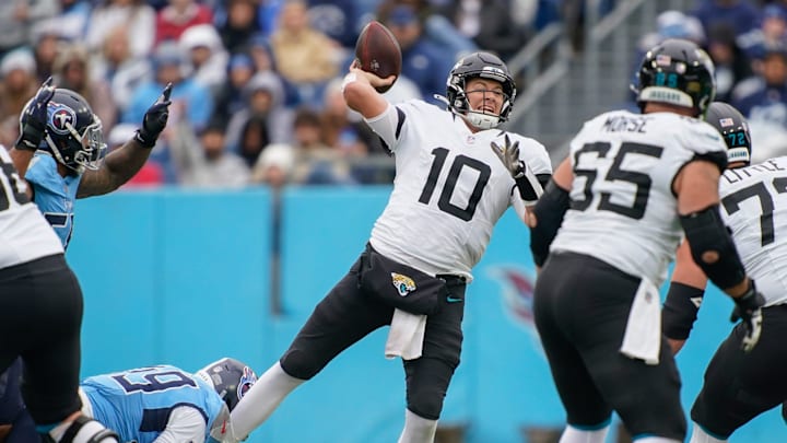 Jacksonville Jaguars quarterback Mac Jones (10) tries to complete a pass with Tennessee Titans linebacker Arden Key (49) on his ankle during the second quarter at Nissan Stadium in Nashville, Tenn., Sunday, Dec. 8, 2024.