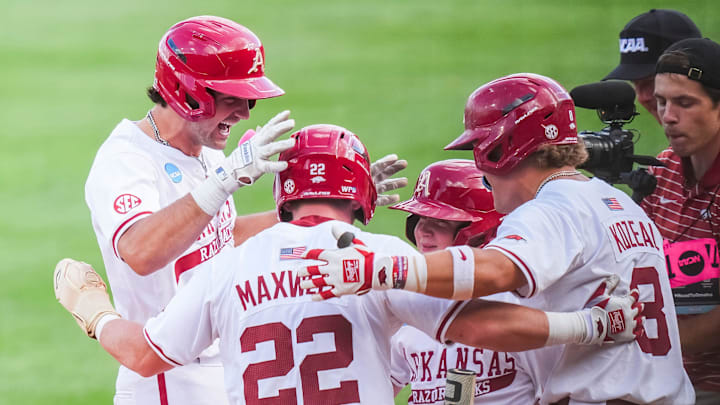 Arkansas' Ryder Helfrick (27) celebrates with teammates at home plate after hitting a two-run home run during game one of the NCAA baseball tournament Fayetteville Super Regional between Tennessee and Arkansas held at Baum-Walker Stadium on Saturday, June 7, 2025. Arkansas' Ryder Helfrick (27) celebrates with teammates at home plate after hitting a two-run home run during game one of the NCAA baseball tournament Fayetteville Super Regional between Tennessee and Arkansas held at Baum-Walker Stadium on Saturday, June 7, 2025.