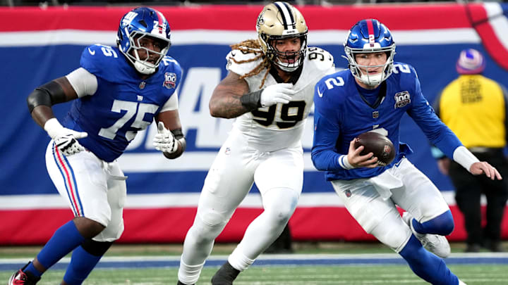 New York Giants quarterback Drew Lock (2) runs away from New York Giants place kicker Jude McAtamney New Orleans Saints defensive end Chase Young (99), Sunday, December 8, 2024.