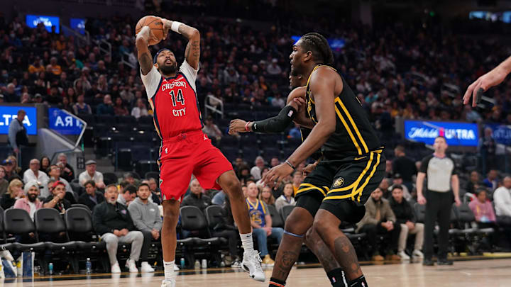 Jan 10, 2024; San Francisco, California, USA; New Orleans Pelicans forward Brandon Ingram (14) shoots over Golden State Warriors guard Moses Moody (4) and forward Kevon Looney (5) in the third quarter at the Chase Center.