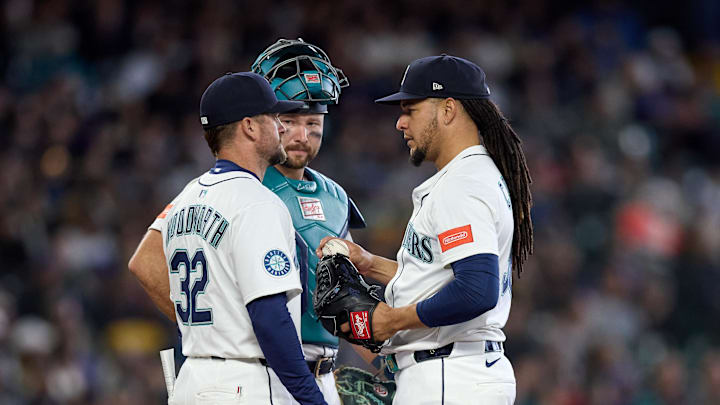 Seattle Mariners starting pitcher Luis Castillo (58), right, talks with Seattle Mariners pitching coach Pete Woodworth (32) and Seattle Mariners catcher Cal Raleigh (29) on the mound during the sixth inninng against the New York Yankees at T-Mobile Park on May 14. 