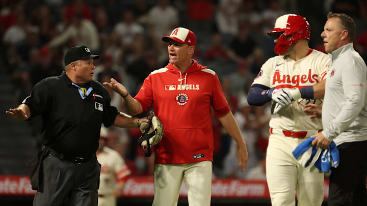 Jul 29, 2025; Anaheim, California, USA;  Los Angeles Angels interim manager Ray Montgomery (81, center) yells toward the Texas Rangers bench as home plate umpire Marvin Hudson (left) gestures after designated hitter Mike Trout (27) was hit by a pitch during the eighth inning at Angel Stadium. Mandatory Credit: Kiyoshi Mio-Imagn Images