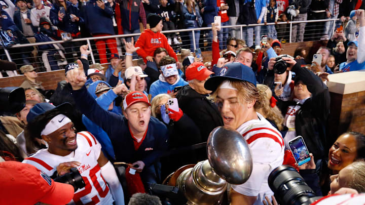 Nov 23, 2023; Starkville, Mississippi, USA; Mississippi Rebels quarterback Jaxson Dart (2) shares the Egg Bowl trophy with fans after defeating the Mississippi State Bulldogs at Davis Wade Stadium at Scott Field. Mandatory Credit: Petre Thomas-Imagn Images