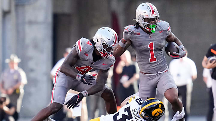 Iowa Hawkeyes defensive back Quinn Schulte tackles Ohio State Buckeyes running back Quinshon Judkins.