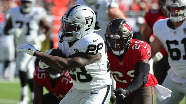 Dec 8, 2024; Tampa, Florida, USA; Las Vegas Raiders running back Sincere McCormick (28) runs past Tampa Bay Buccaneers safety Christian Izien (29) during the second quarter at Raymond James Stadium. Mandatory Credit: Kim Klement Neitzel-Imagn Images
