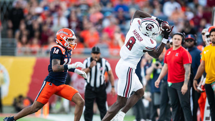 Dec 31, 2024; Orlando, FL, USA; South Carolina Gamecocks wide receiver Nyck Harbor (8) makes the catch over Illinois Fighting Illini defensive back Xavier Scott (14) in the third quarter at Camping World Stadium. Mandatory Credit: Jeremy Reper-Imagn Images