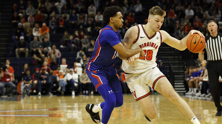 Dec 22, 2025; Charlottesville, Virginia, USA; Virginia Cavaliers forward Thijs de Ridder (28) dribbles the ball as American University Eagles guard Geoff Sprouse (12) defends in the second half at John Paul Jones Arena. Mandatory Credit: Geoff Burke-Imagn Images