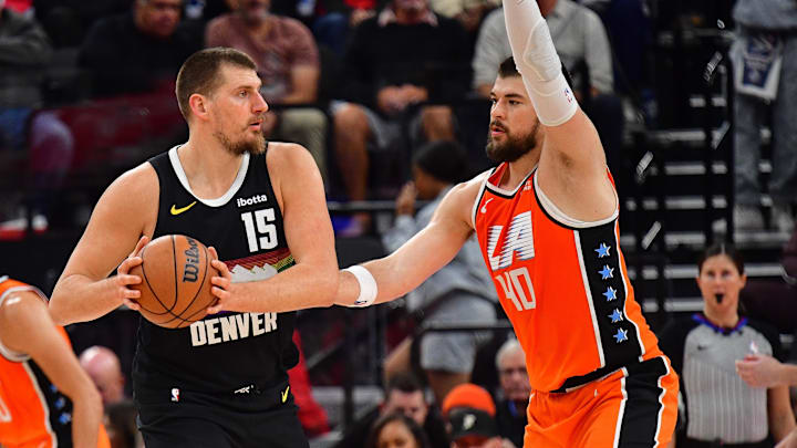 Nov 12, 2025; Inglewood, California, USA; Denver Nuggets center Nikola Jokic (15) controls the ball against Los Angeles Clippers center Ivica Zubac (40) during the first half at Intuit Dome. Mandatory Credit: Gary A. Vasquez-Imagn Images