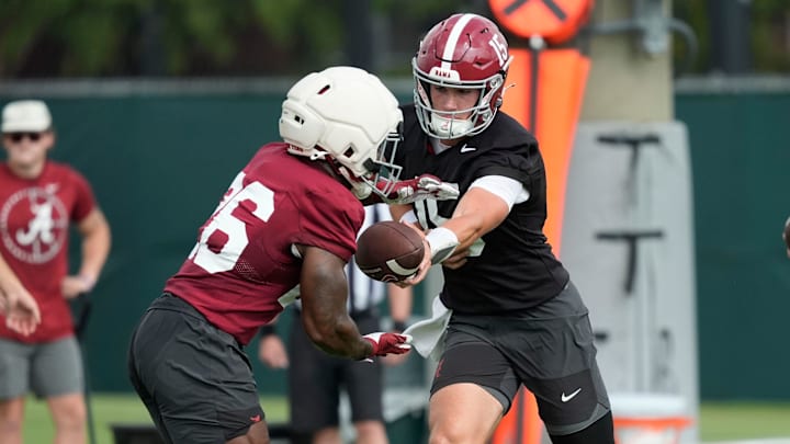 July 30, 2025; Tuscaloosa, AL, USA; Quarterback Ty Simpson hands off to running back Jam Miller during the first practice session of the preseason for the Alabama Crimson Tide.