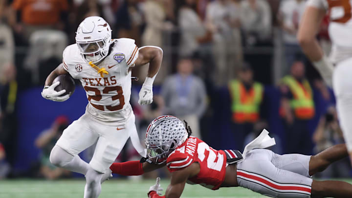 Jan 10, 2025; Arlington, Texas, USA; Texas Longhorns running back Jaydon Blue (23) is tackled by Ohio State Buckeyes cornerback Jermaine Mathews Jr. (24) during the third quarter of the College Football Playoff semifinal in the Cotton Bowl at AT&T Stadium. Mandatory Credit: Tim Heitman-Imagn Images