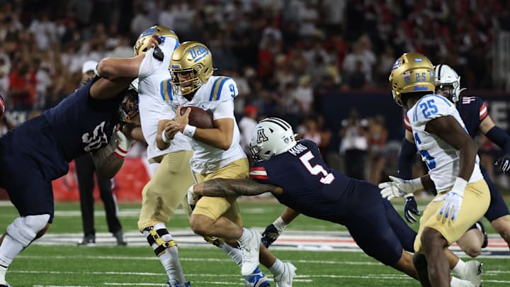 Nov 4, 2023; Tucson, Arizona, USA; Arizona Wildcats linebacker Jacob Manu #5 makes a tackle against UCLA Bruins quarterback Collin Schlee #9 during the second half at Arizona Stadium. Mandatory Credit: Zachary BonDurant-Imagn Images Nov 4, 2023; Tucson, Arizona, USA; Arizona Wildcats linebacker Jacob Manu #5 makes a tackle against UCLA Bruins quarterback Collin Schlee #9 during the second half at Arizona Stadium. Mandatory Credit: Zachary BonDurant-Imagn Images