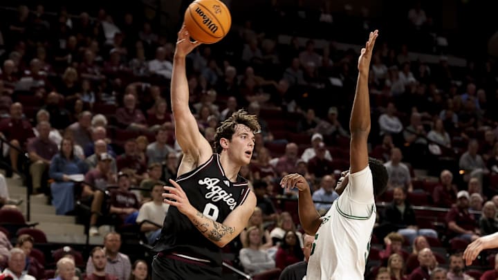 Nov 21, 2025; College Station, Texas, USA; Texas A&M Aggies guard Ruben Dominguez (9) passes the ball over Manhattan Jaspers guard Erik Oliver-Bush (5) during the first half at Reed Arena. Mandatory Credit: Maria Lysaker-Imagn Images 