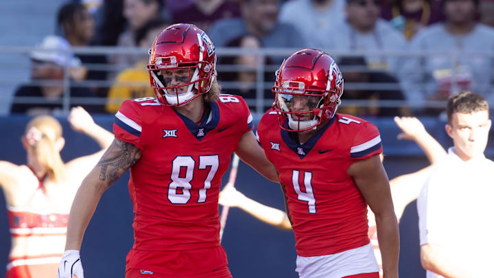 Nov 30, 2024; Tucson, Arizona, USA; Arizona Wildcats wide receiver Tetairoa McMillan (4) celebrates a touchdown with tight end Tyler Powell (87) against the Arizona State Sun Devils during the Territorial Cup at Arizona Stadium. Mandatory Credit: Mark J. Rebilas-Imagn Images