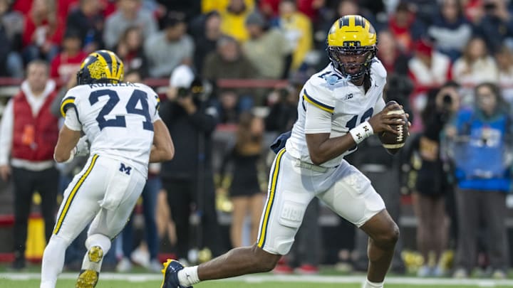 Nov 22, 2025; College Park, Maryland, USA;  Michigan Wolverines quarterback Bryce Underwood (19) rolls out to pass during the ]first half against the Maryland Terrapins at SECU Stadium. Mandatory Credit: Tommy Gilligan-Imagn Images