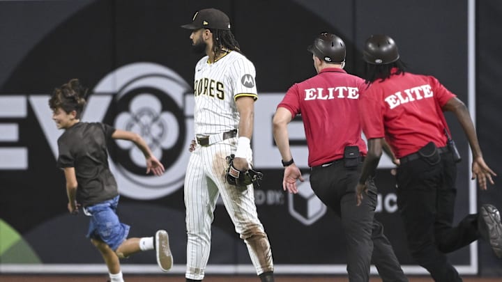 Aug 19, 2025; San Diego, California, USA; San Diego Padres right fielder Fernando Tatis Jr. (23) looks on as security guards chase a young fan running on the field during the eighth inning during a game against the San Francisco Giants at Petco Park. Mandatory Credit: Denis Poroy-Imagn Images