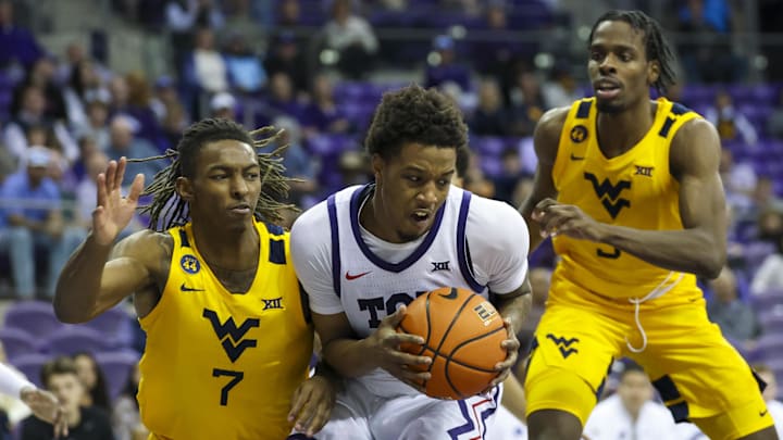 Feb 5, 2025; Fort Worth, Texas, USA;  TCU Horned Frogs guard Vasean Allette (3) controls the ball as West Virginia Mountaineers guard Javon Small (7) and West Virginia Mountaineers guard Toby Okani (5) defend during the second half at Ed and Rae Schollmaier Arena. Mandatory Credit: Kevin Jairaj-Imagn Images