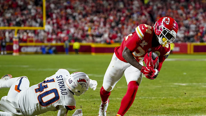 Dec 25, 2025; Kansas City, Missouri, USA; Kansas City Chiefs running back Brashard Smith (24) scores a touchdown as Denver Broncos linebacker Justin Strnad (40) attempts to tackle at GEHA Field at Arrowhead Stadium. Mandatory Credit: Denny Medley-Imagn Images